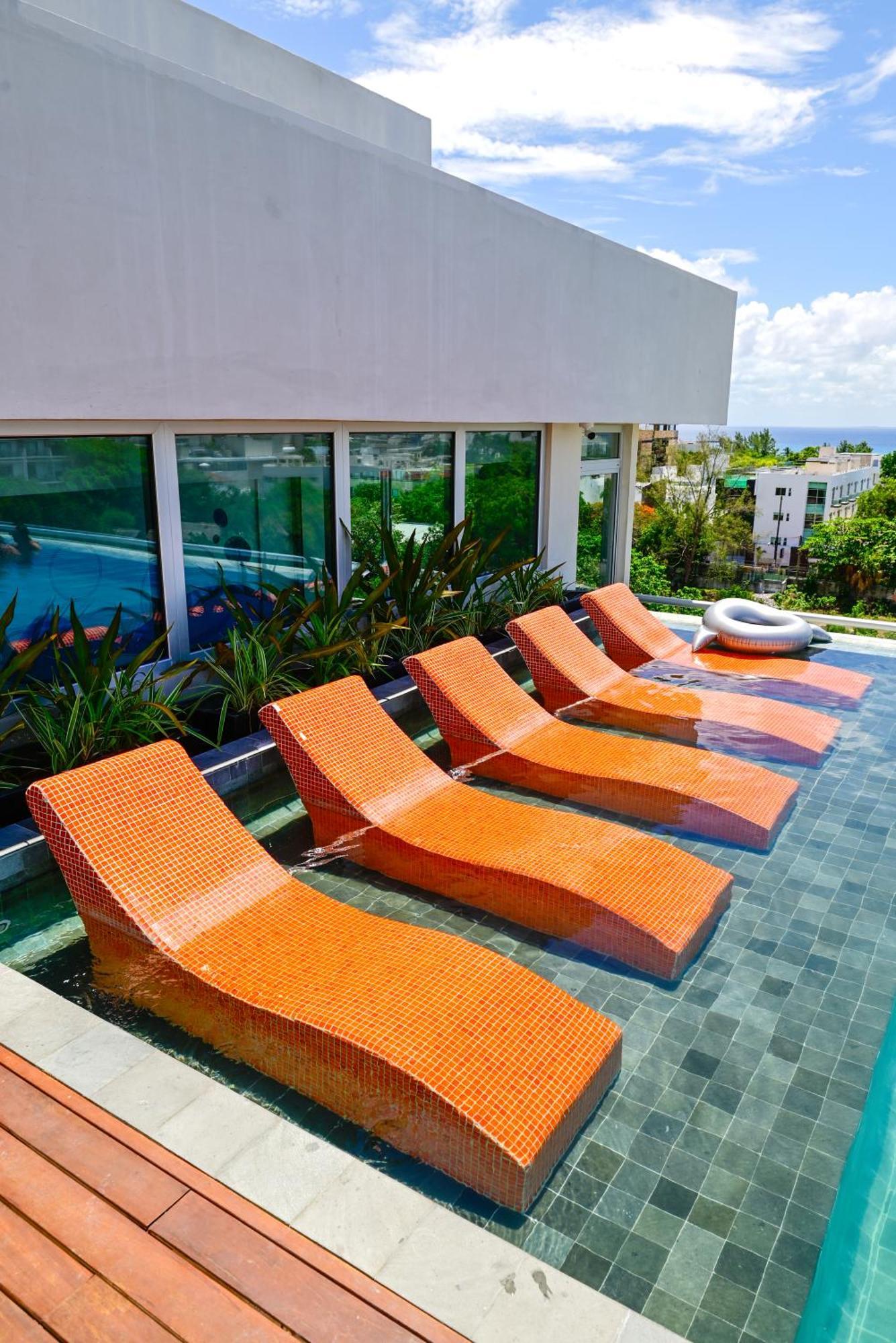 Aloft Playa Del Carmen Hotel Exterior foto Sunbathing chairs at a pool